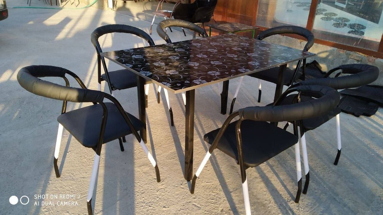 Qora naqshli stol va yumshoq stullar